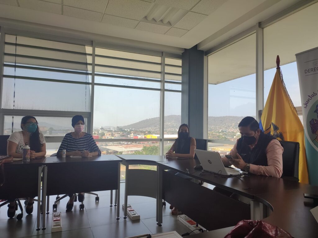 Mesa de trabajo en una sala con ventanales.