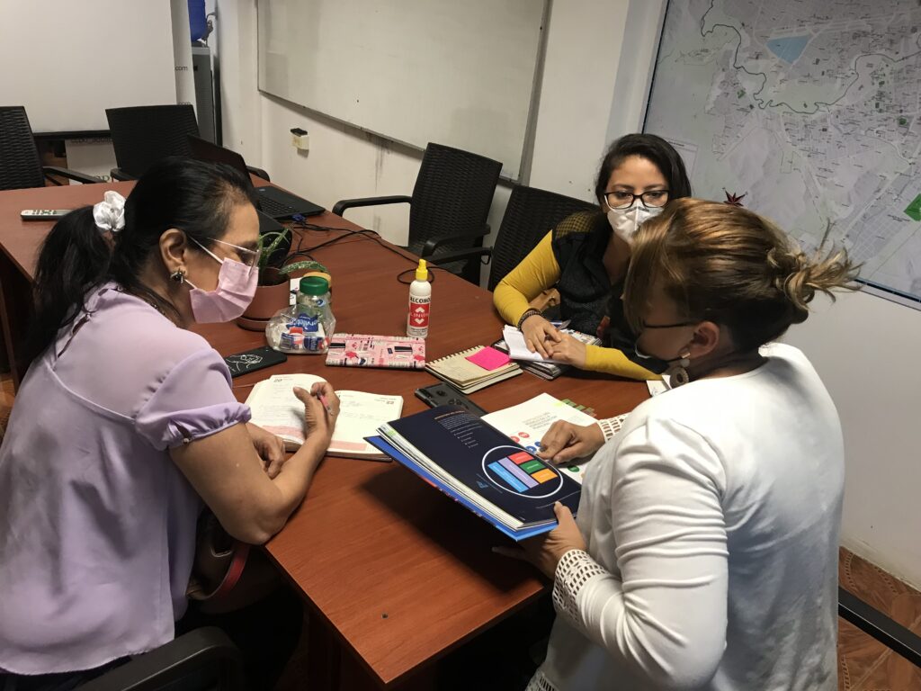 Reunión de trabajo alrededor de una mesa con documentos.